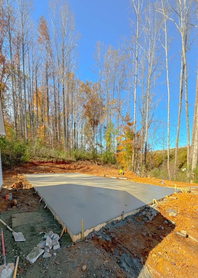 Tapered slab edge sloped away from the base rail of a metal building