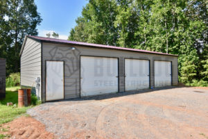 Three-car metal garage with gray siding.