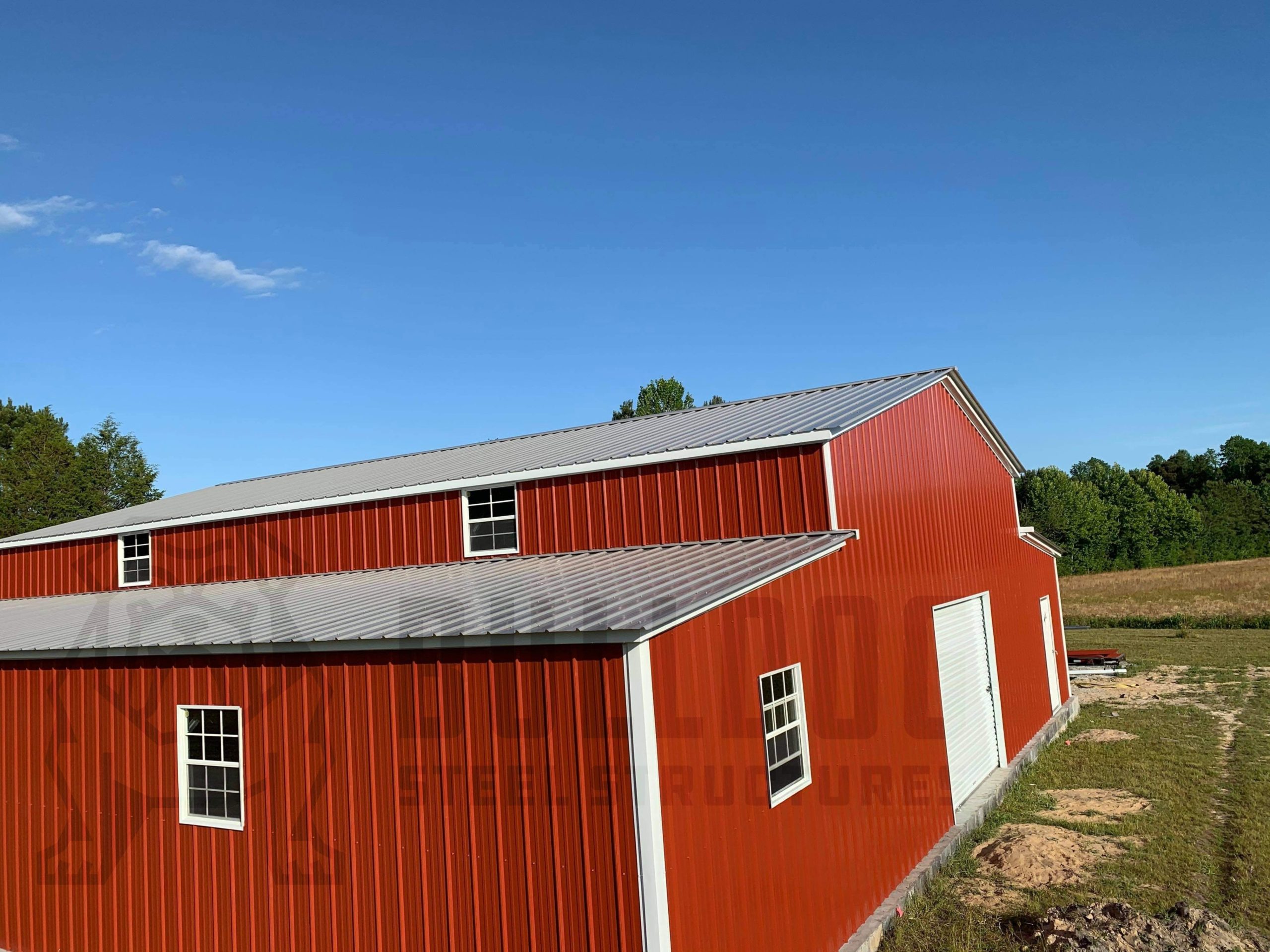 Exterior of red barn with white trim and doors